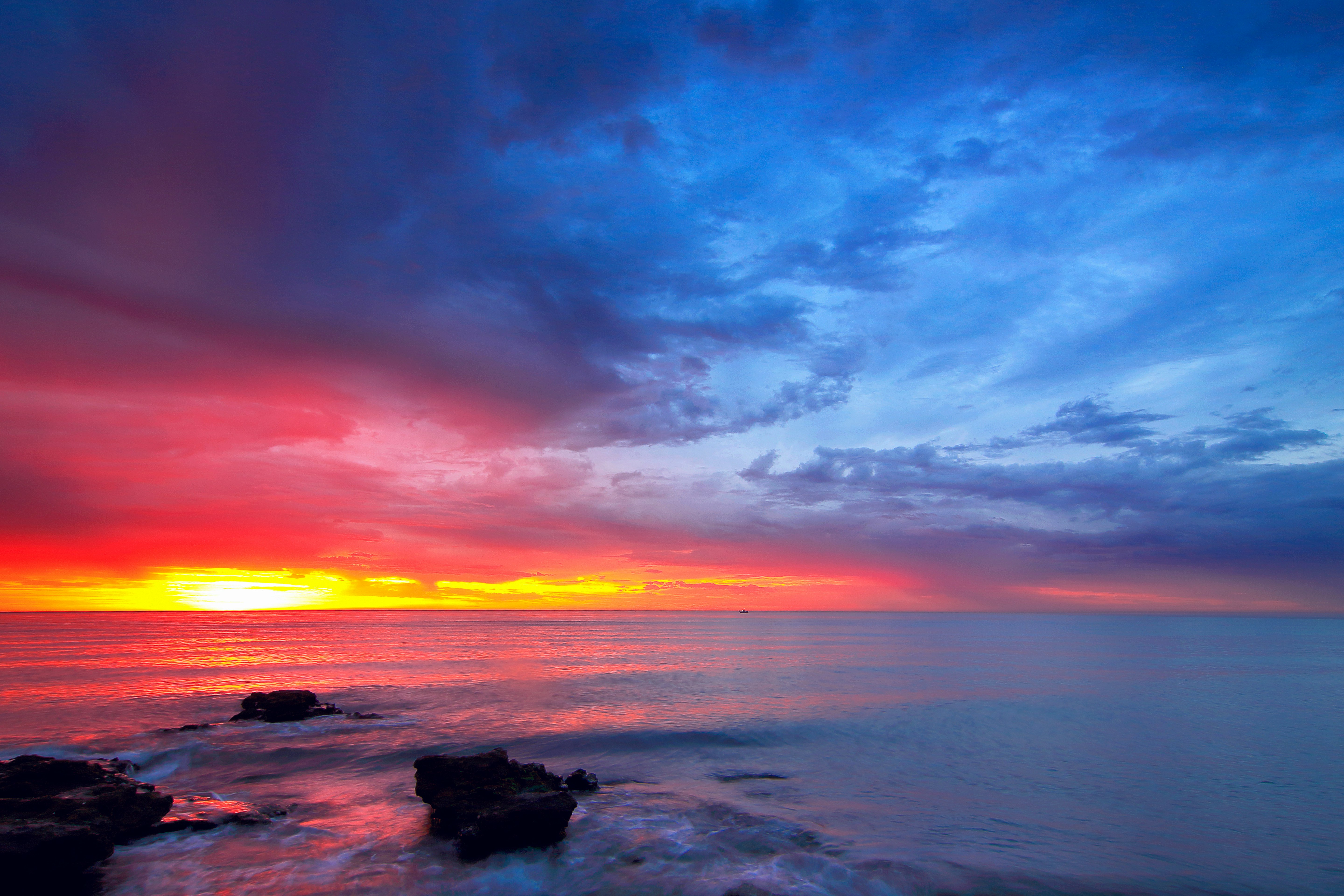 calm sea with rocks during golden hour